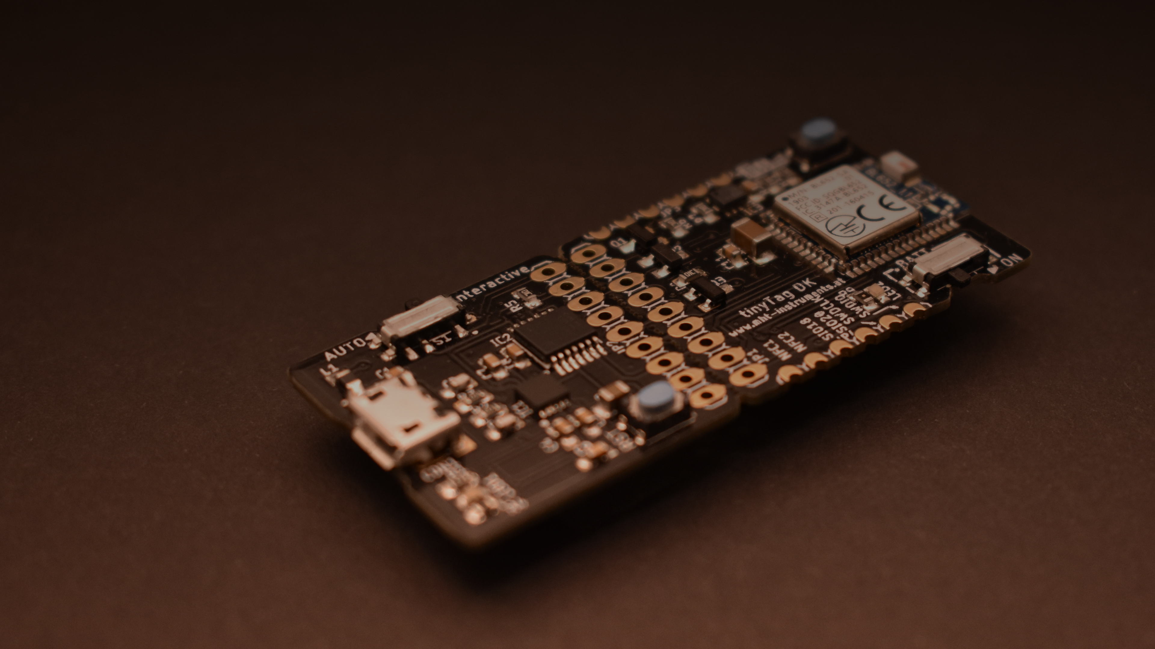 The tinyTag development board lit from the side on a dark surface